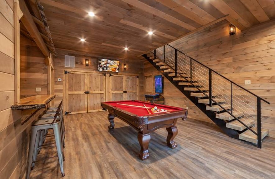 bar and pool table with large staircase